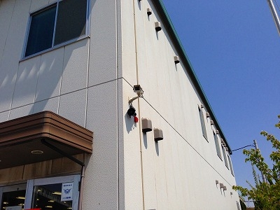 入口周辺を監視する建物の外壁に設置された防犯カメラ